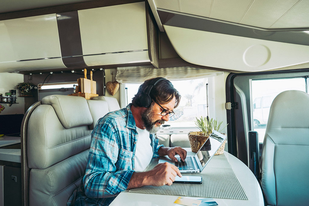 man using laptop in rv