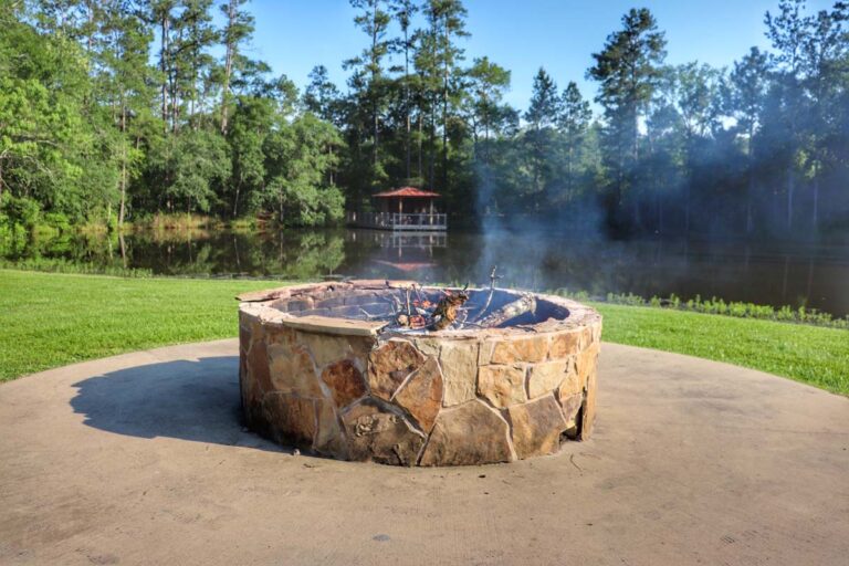 fire pit in front of lake and trees