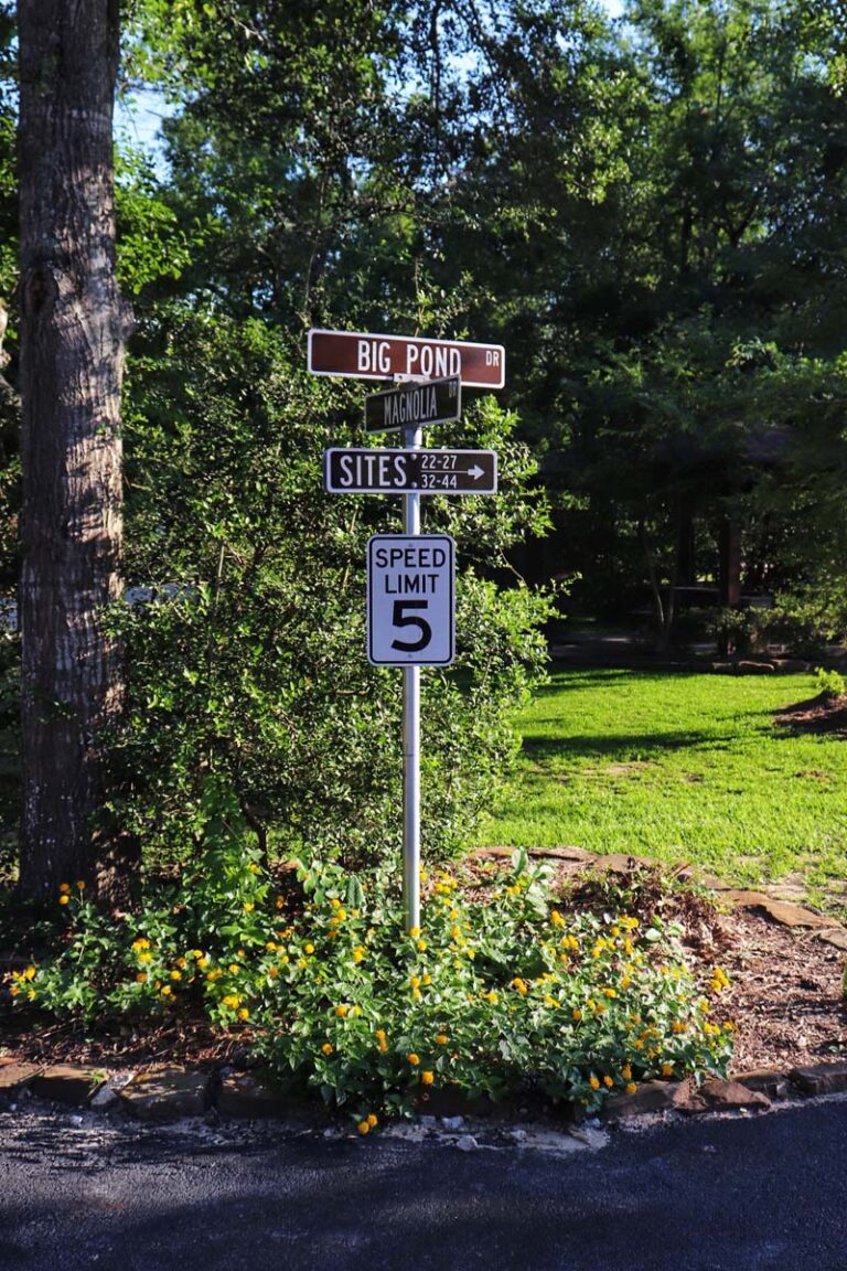 street signs with grass and trees