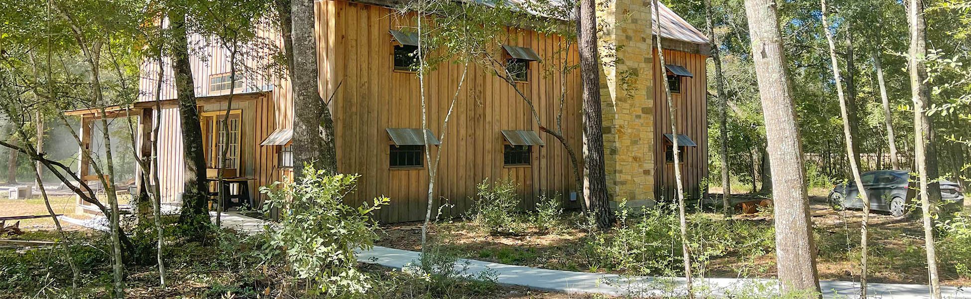 barnwoods barn between trees with car parked